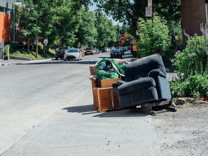 Old recliner, chair and boxes left at the curb
