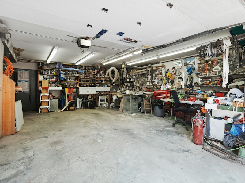Garage cluttered with shelves, tools and stored items