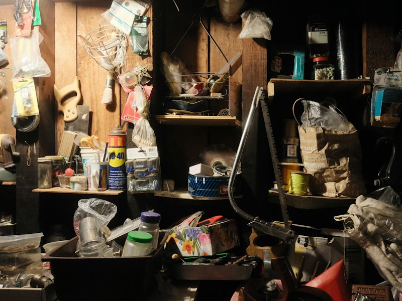 Basement shelves crowded with old tools, jars and clutter